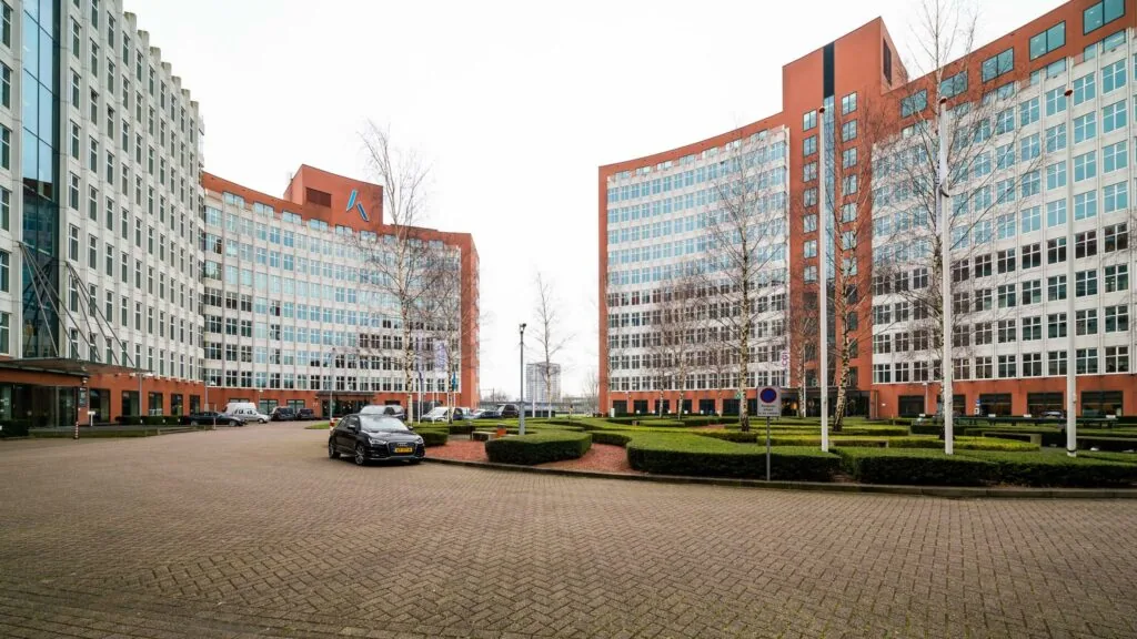 Kantoorgebouwen aan de George Hintzenweg met symmetrische architectuur en verzorgde beplanting op de voorgrond.